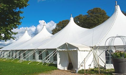 a line of portable restrooms in a shaded area, offering a comfortable experience for users in Parlier